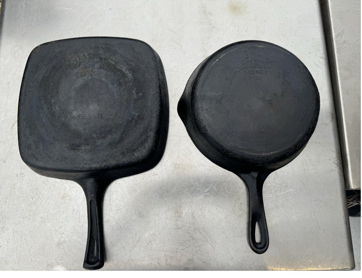 The same two Wagner skillets before restoration, covered in black crust